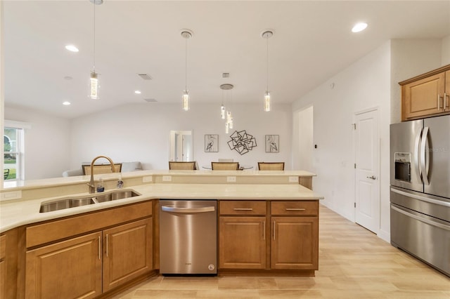 kitchen with sink, light hardwood / wood-style flooring, decorative light fixtures, and appliances with stainless steel finishes