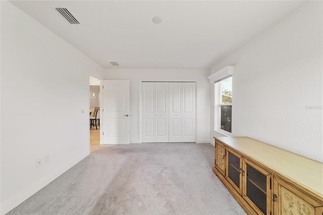 interior space with light carpet and a closet