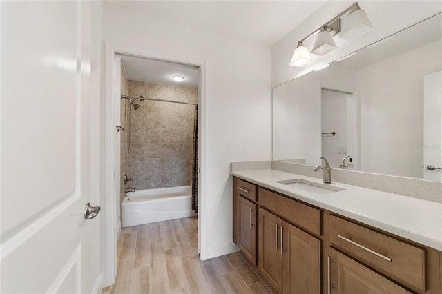 bathroom featuring hardwood / wood-style floors, vanity, and tiled shower / bath