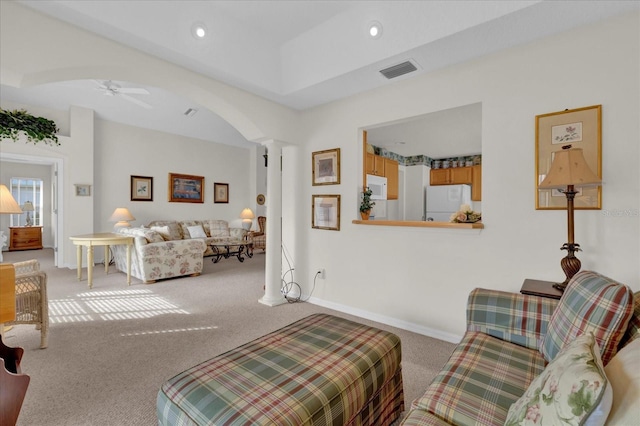 carpeted living room with a tray ceiling, ornate columns, and ceiling fan