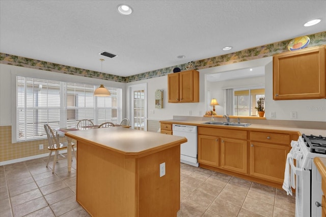 kitchen featuring sink, a center island, a textured ceiling, decorative light fixtures, and white appliances