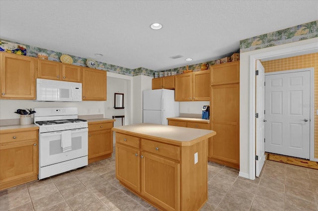 kitchen with a textured ceiling, white appliances, and a center island