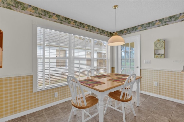 tiled dining room featuring a textured ceiling