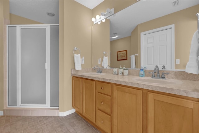 bathroom with tile patterned flooring, vanity, and a shower with door