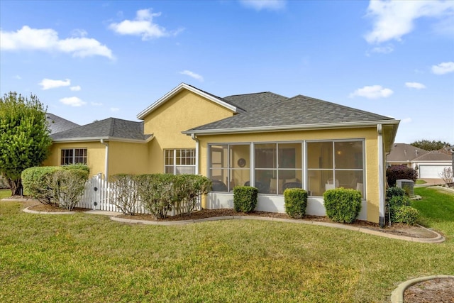 rear view of property featuring a lawn and a sunroom