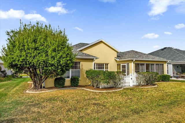 view of front of home featuring a sunroom and a front lawn