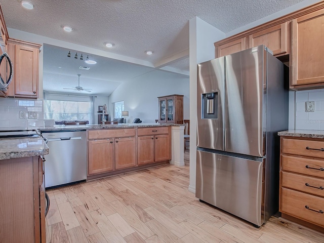 kitchen featuring tasteful backsplash, a textured ceiling, light hardwood / wood-style flooring, ceiling fan, and stainless steel appliances