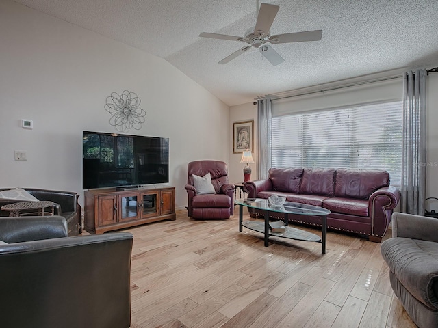 living room with lofted ceiling, a wealth of natural light, and light hardwood / wood-style flooring