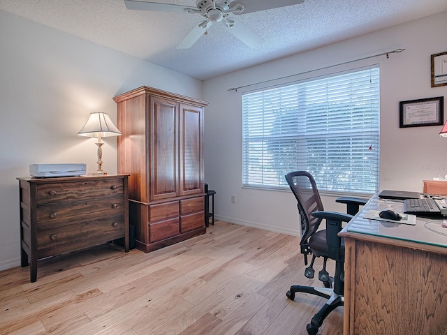 office area with a textured ceiling, ceiling fan, and light wood-type flooring