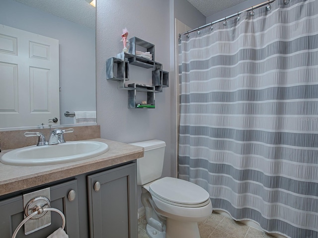 bathroom featuring vanity, toilet, and a textured ceiling