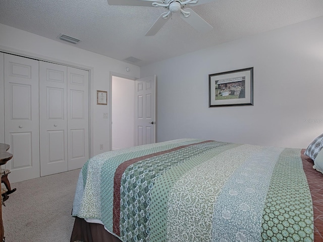 carpeted bedroom featuring a textured ceiling, a closet, and ceiling fan