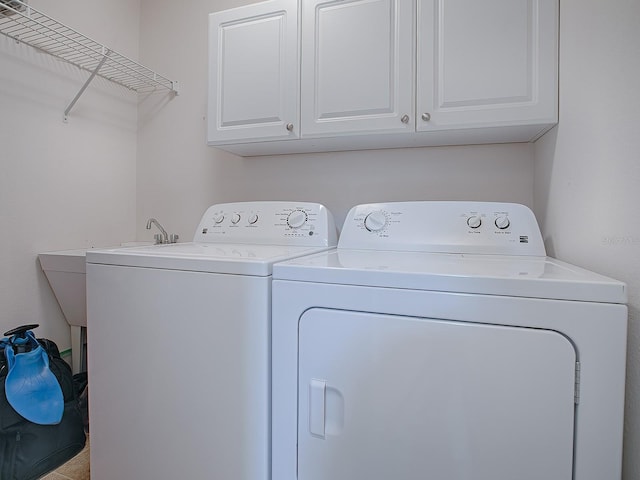 washroom with cabinets and washing machine and dryer