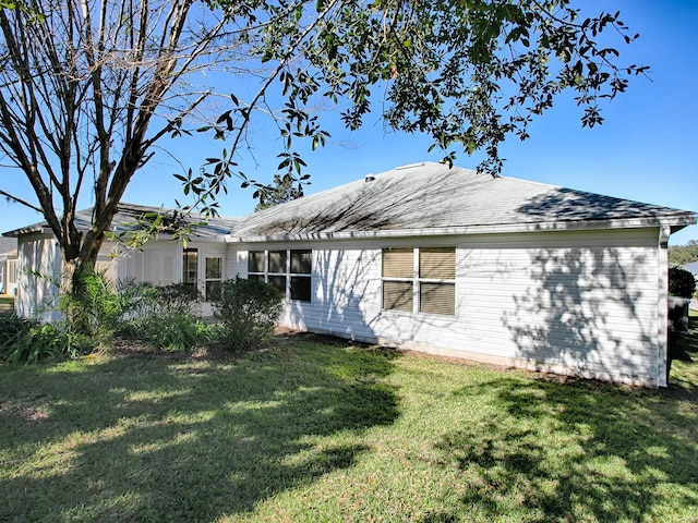 rear view of property featuring a yard