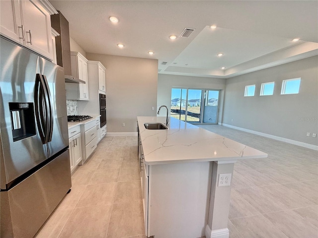 kitchen featuring sink, white cabinetry, stainless steel appliances, and a kitchen island with sink