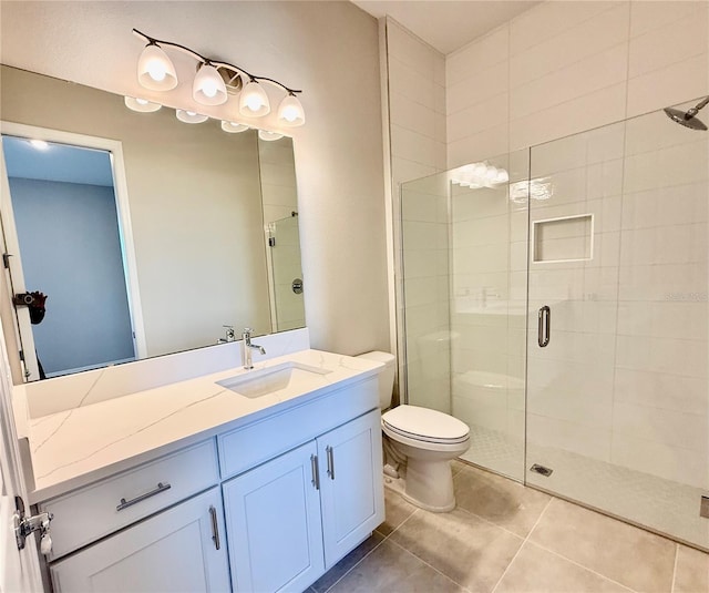 bathroom with tile patterned floors, vanity, toilet, and a shower with shower door