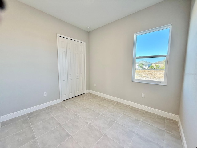 unfurnished bedroom with a closet and light tile patterned flooring