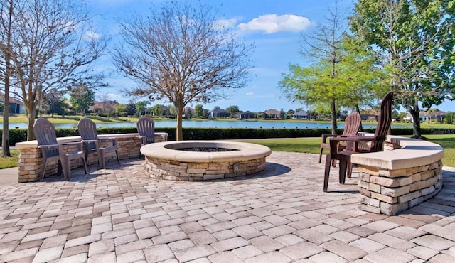 view of patio with a water view and a fire pit