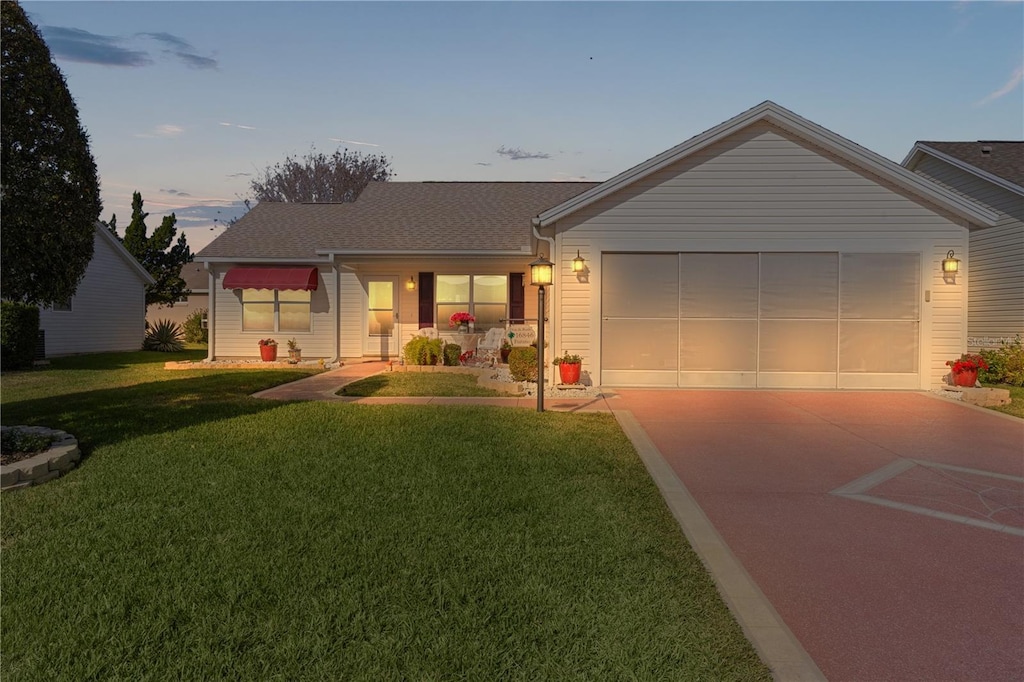 ranch-style house with a garage and a yard