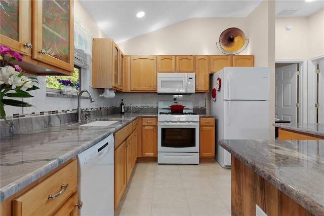 kitchen with tasteful backsplash, white appliances, lofted ceiling, dark stone countertops, and sink