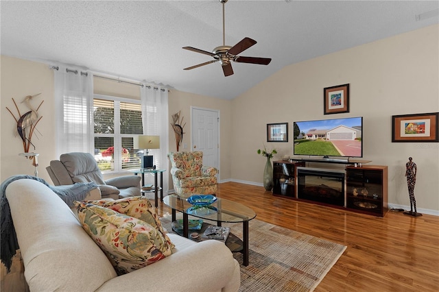 living room featuring a textured ceiling, ceiling fan, lofted ceiling, and wood-type flooring