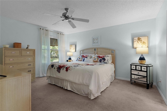 bedroom with ceiling fan, light colored carpet, and a textured ceiling