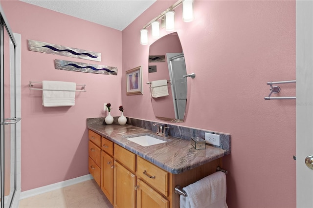 bathroom featuring vanity, a shower with door, and a textured ceiling