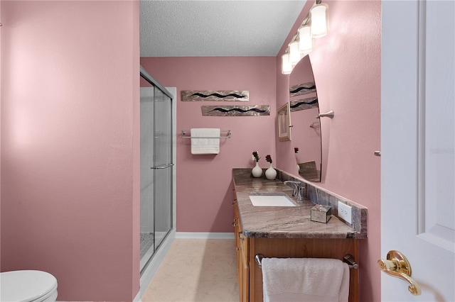 bathroom with a textured ceiling, toilet, an enclosed shower, and vanity