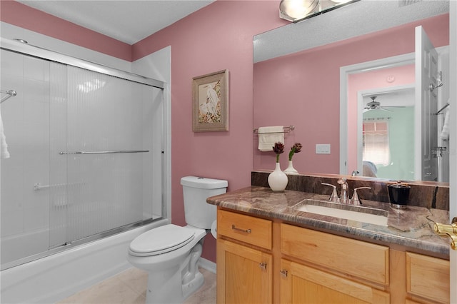 full bathroom with ceiling fan, vanity, toilet, tile patterned floors, and enclosed tub / shower combo