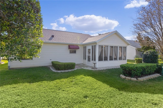 back of property featuring a yard and a sunroom