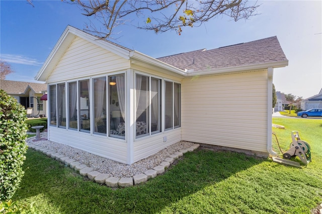 view of side of home featuring a sunroom and a yard