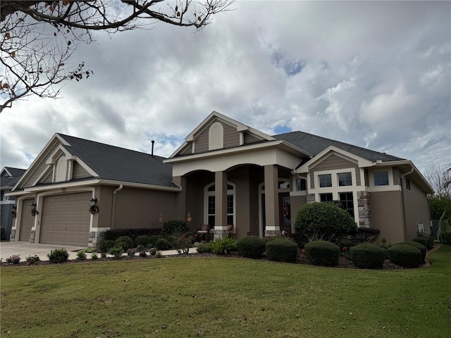 view of front facade with a front yard, a garage, and covered porch