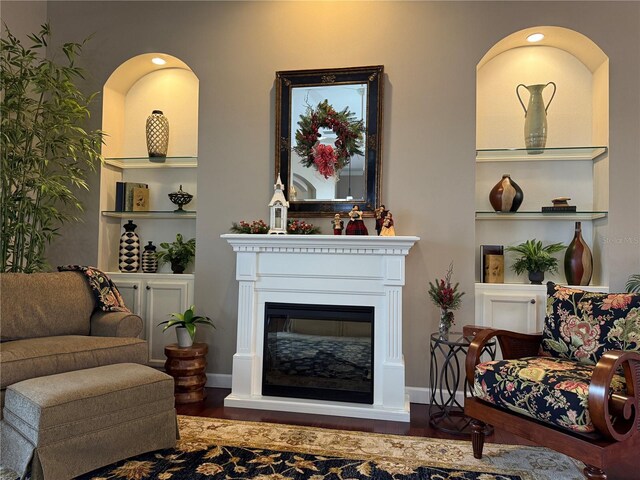 living room with built in features and hardwood / wood-style flooring