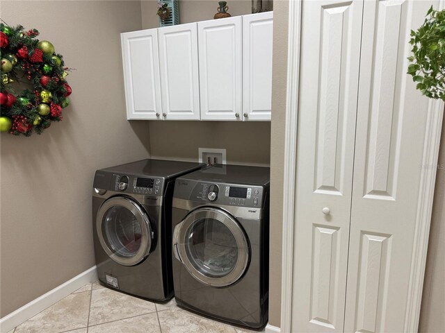 laundry area featuring cabinets, independent washer and dryer, and light tile patterned floors