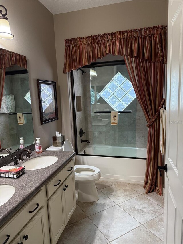 full bathroom featuring shower / bath combination with glass door, tile patterned flooring, vanity, and toilet