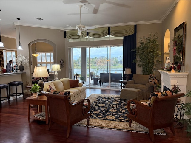 living room with dark hardwood / wood-style floors, plenty of natural light, ceiling fan, and crown molding