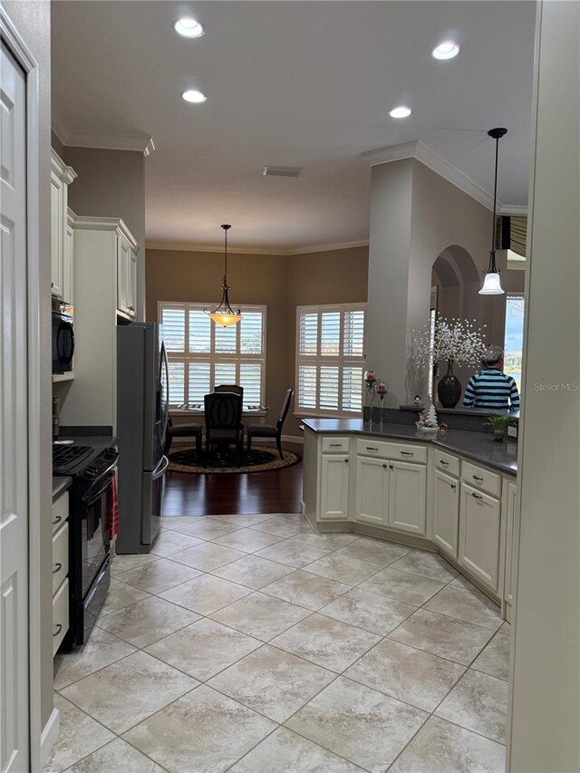 kitchen with electric range, stainless steel fridge, decorative light fixtures, white cabinets, and ornamental molding