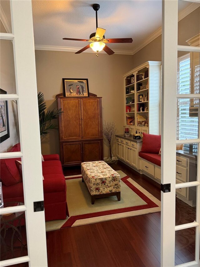 sitting room with dark hardwood / wood-style floors, ceiling fan, and crown molding