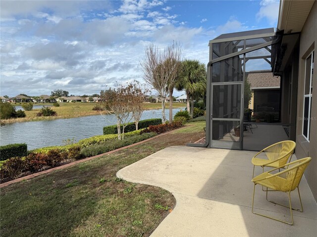 view of yard featuring a water view, a patio area, and a lanai