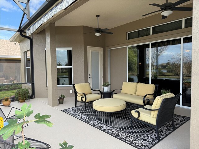 view of patio with ceiling fan, an outdoor hangout area, and glass enclosure