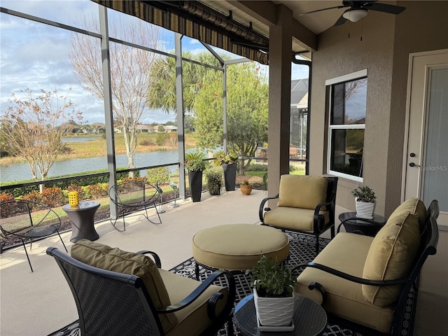 sunroom / solarium with a water view and ceiling fan