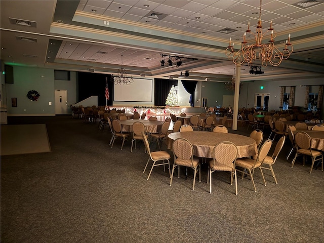 carpeted dining area with a tray ceiling and ornamental molding