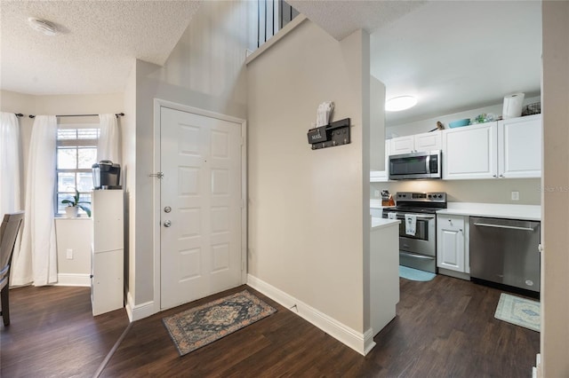 foyer featuring dark hardwood / wood-style flooring and a textured ceiling