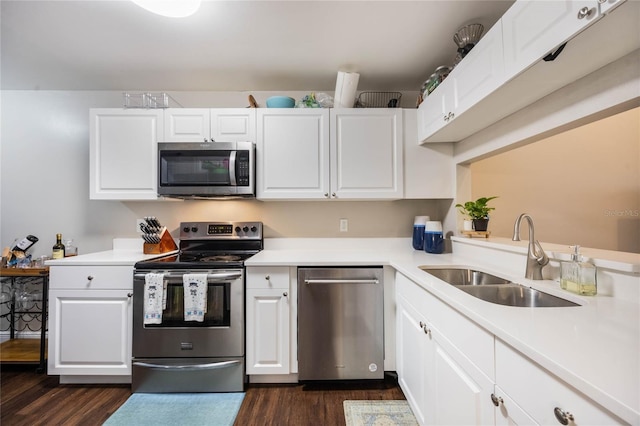 kitchen with stainless steel appliances, white cabinetry, sink, and dark hardwood / wood-style floors