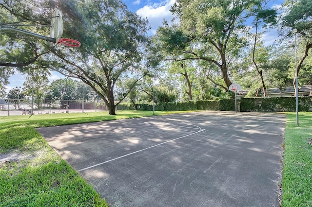 view of sport court with a lawn