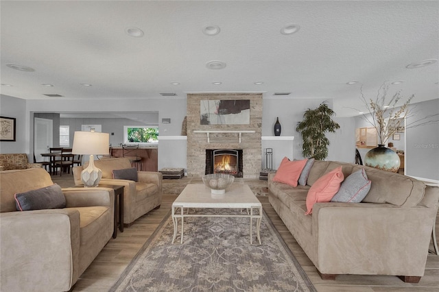 living room featuring hardwood / wood-style floors, a fireplace, and a textured ceiling