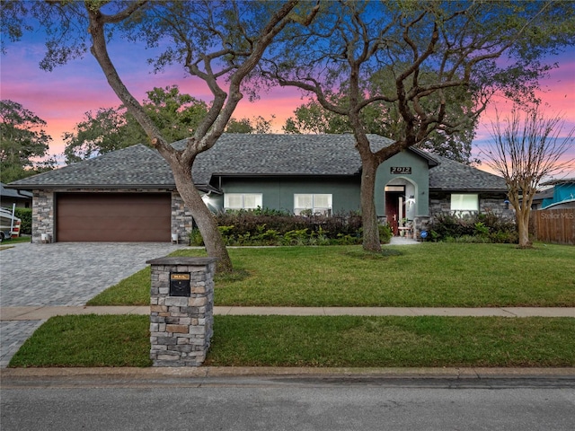 single story home featuring a lawn and a garage