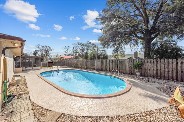 view of swimming pool with a sunroom and a patio area