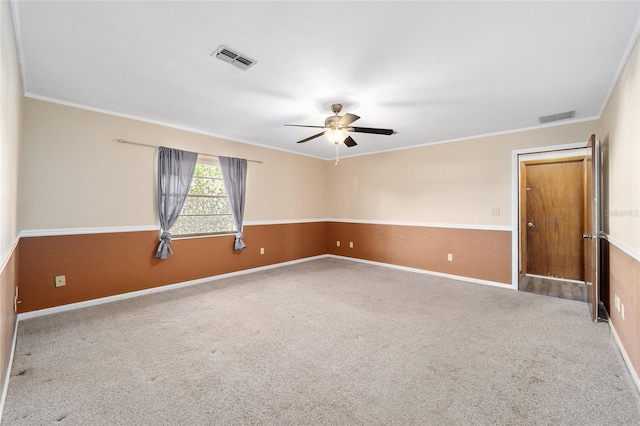 carpeted spare room with ceiling fan and ornamental molding