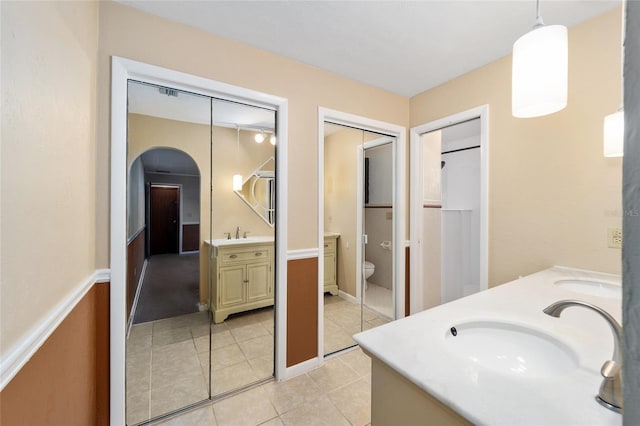 bathroom featuring vanity, tile patterned floors, and toilet