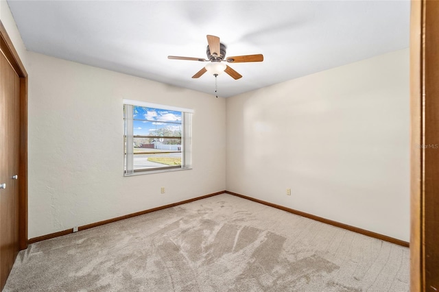 carpeted spare room with ceiling fan